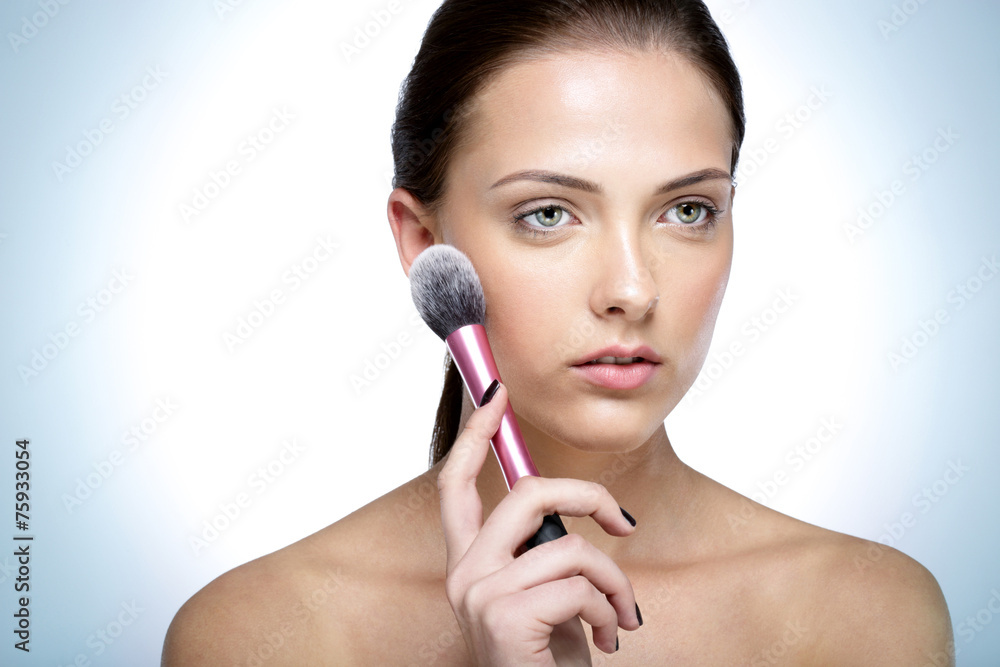 Portrait of a young beautful woman holding cosmetic brush Portrait of a young beautful woman holding cosmetic brush