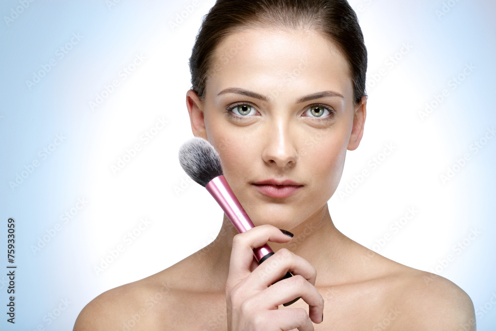 Closeup portrait of a beautiful woman holding brush for makeup Closeup portrait of a beautiful woman holding brush for makeup