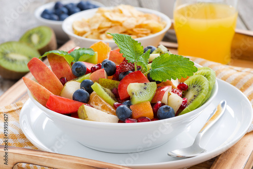 breakfast with fruit salad, cornflakes and orange juice, close-u