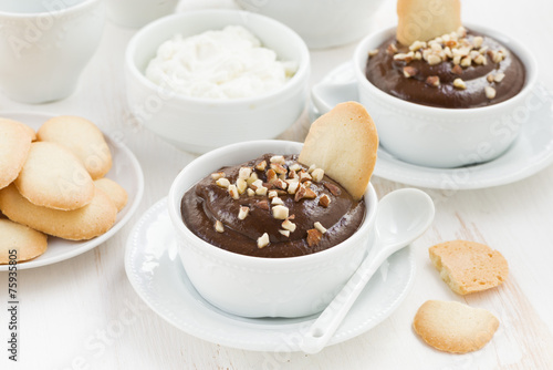 chocolate mousse with biscuits and nuts in white cups