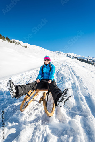 Foto Young woman having fun on a sledge