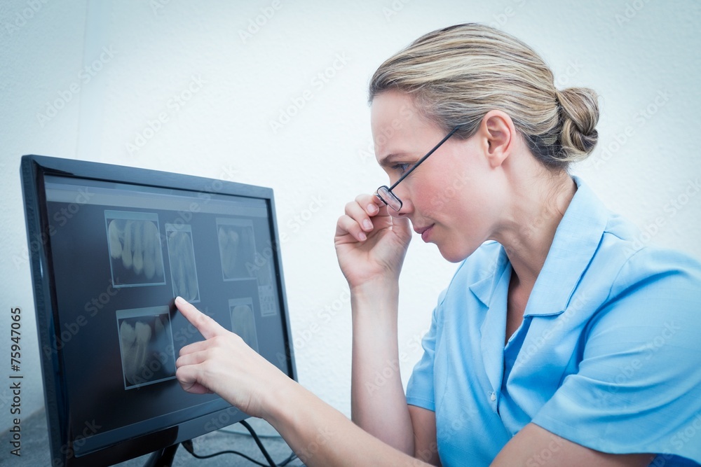 Female dentist looking at x-ray on computer Female dentist looking at x-ray on computer