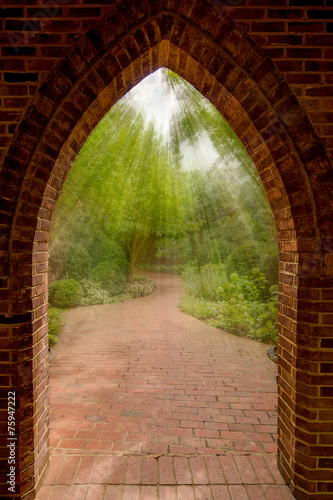 Through an archway the the light streams onto a vanishing garden path