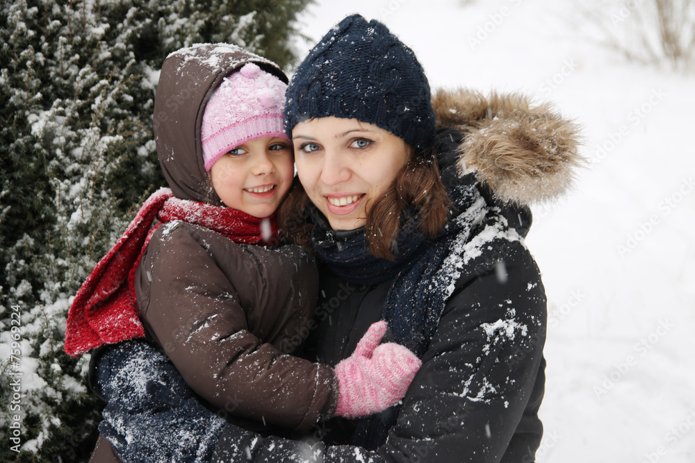 Mother and daughter enjoying snowy weather