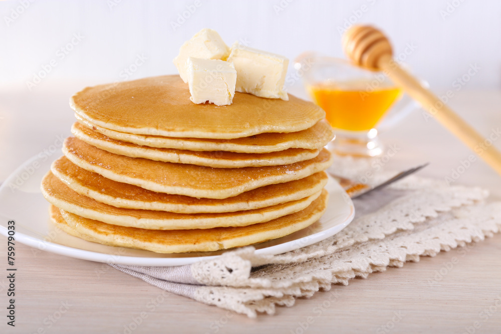 Stack of delicious pancakes with butter and honey in saucer Stack of delicious pancakes with butter and honey in saucer