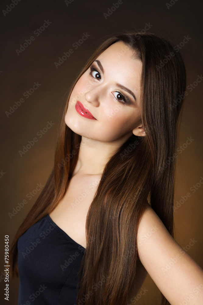 Beautiful young woman with long hair on dark brown background Beautiful young woman with long hair on dark brown background