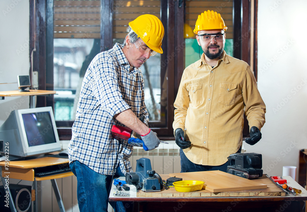 Craftsmen use an electric drill Craftsmen use an electric drill