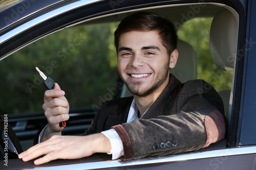 Man with car key in car