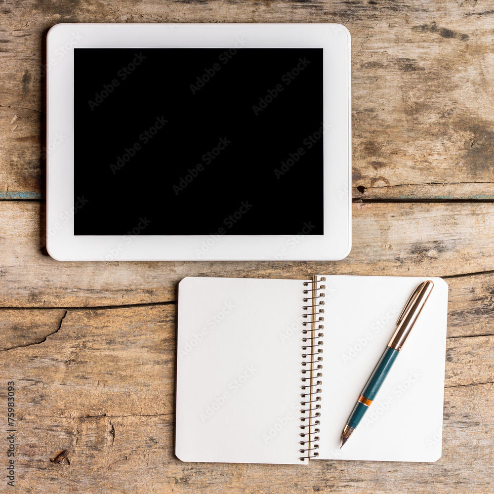 Digital pad with empty black screen and opened notebook Digital pad with empty black screen and opened notebook
