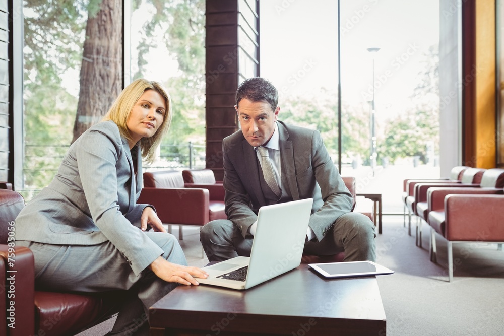 Focused business team having a meeting using laptop Focused business team having a meeting using laptop