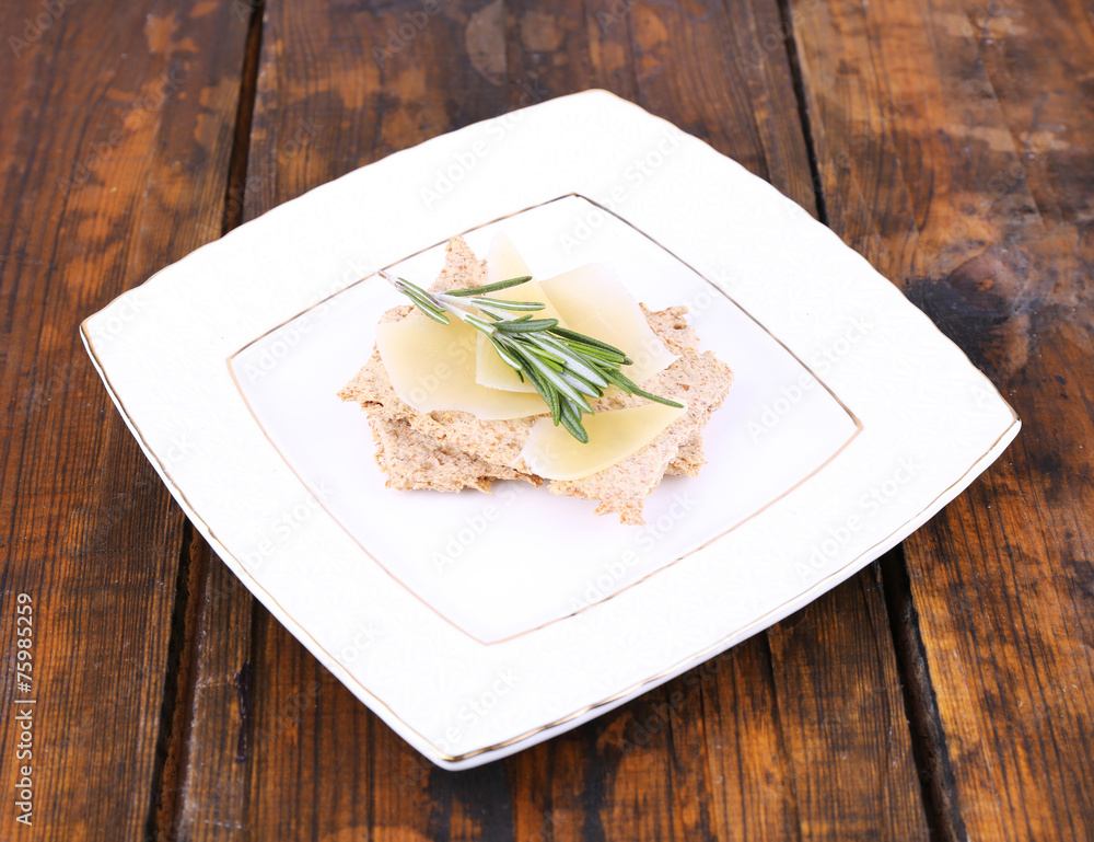 Crispbread with slices of Parmesan cheese with sprig of Crispbread with slices of Parmesan cheese with sprig of