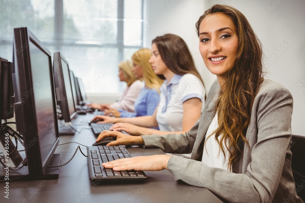 Happy woman in computer room smiling at camera Happy woman in computer room smiling at camera