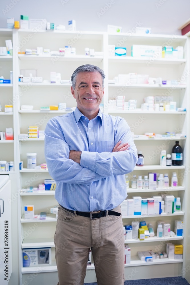 Portrait of a smiling pharmacist standing with arms crossed