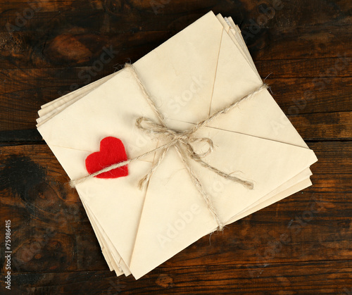 Stack of love letters on rustic wooden planks background