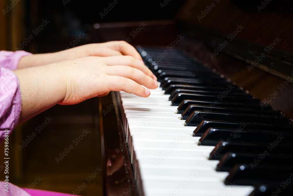 Fototapeta premium Little girl studing to play the piano