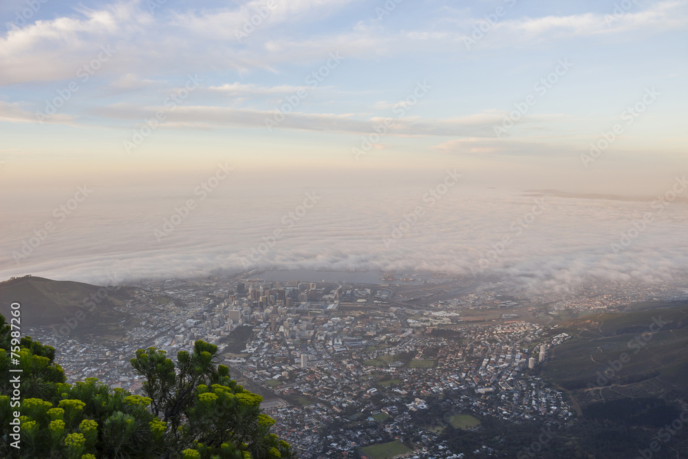 Cape Town covered in fog at sunset from Table Mountain