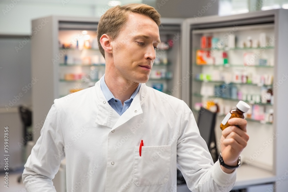 Handsome pharmacist looking at medicine Handsome pharmacist looking at medicine
