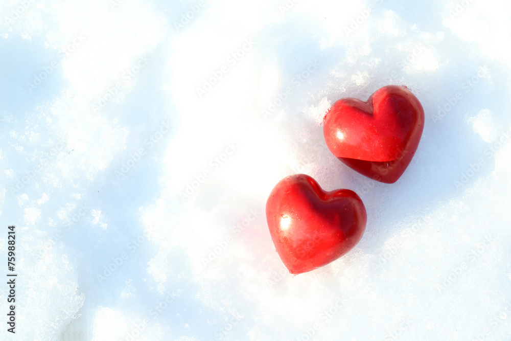 Two red frozen heart on snow background Two red frozen heart on snow background