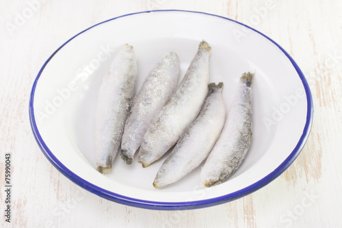 frozen sardines on white dish on white background