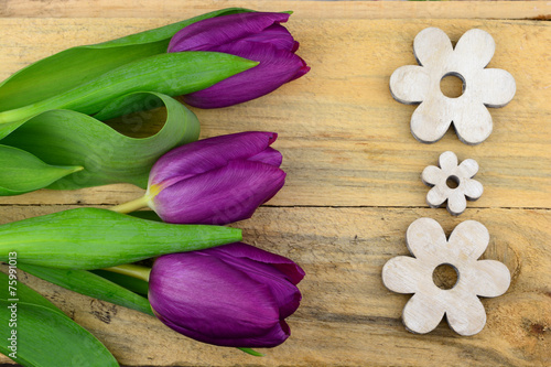 purple tulips and white wooden flowers on old wood