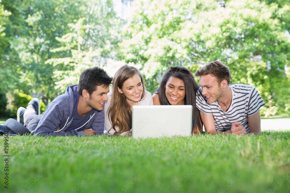 Happy students using laptop outside Happy students using laptop outside