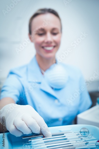 Female dentist picking dental tools