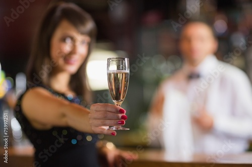 Pretty brunette smiling at camera with champagne