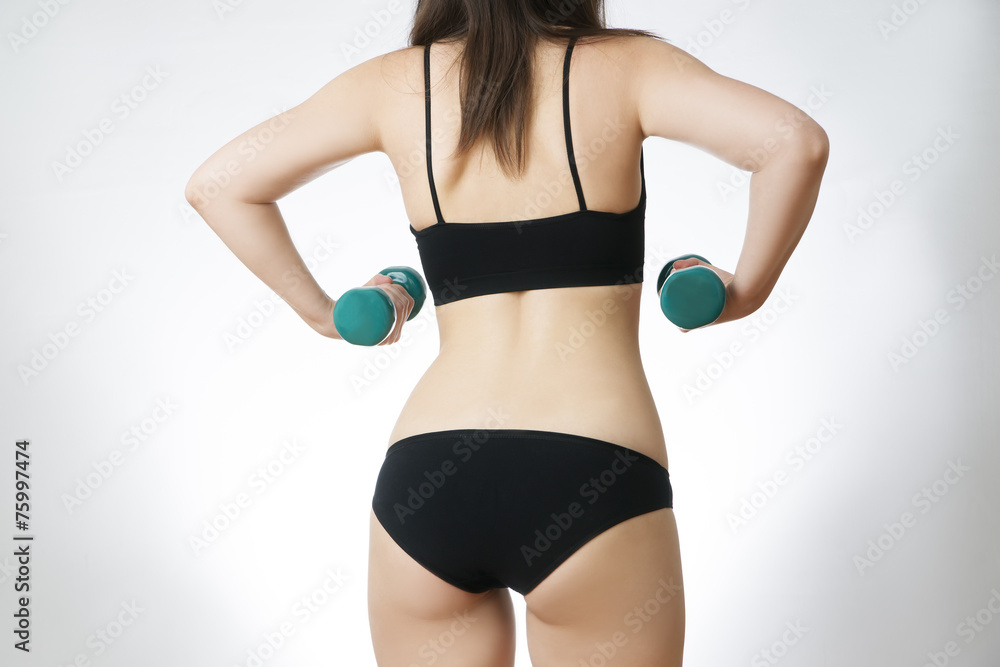 Fototapeta premium Young woman doing exercises with dumbbells