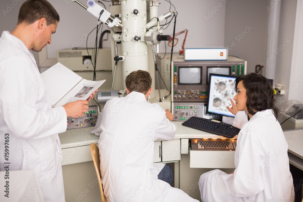 Obraz premium Biochemistry students using large microscope and computer