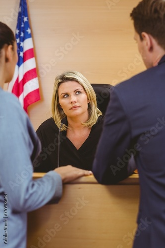 Judge and lawyers speaking in front of the american flag