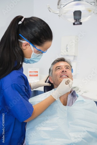 Dentist wearing surgical mask and safety glasses