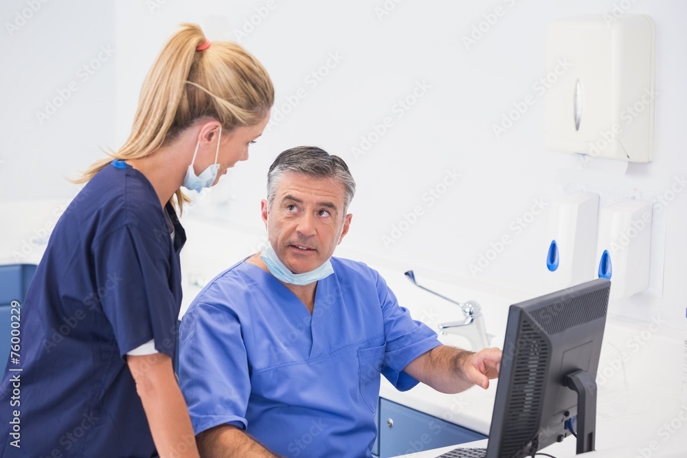 Co-workers using computer and talking Co-workers using computer and talking