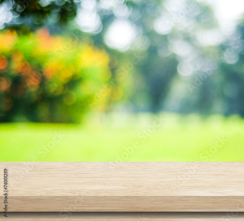Empty wood table with blur green leaves bokeh background
