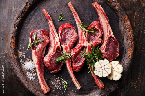 Raw fresh lamb ribs and spicy herbs on dark background