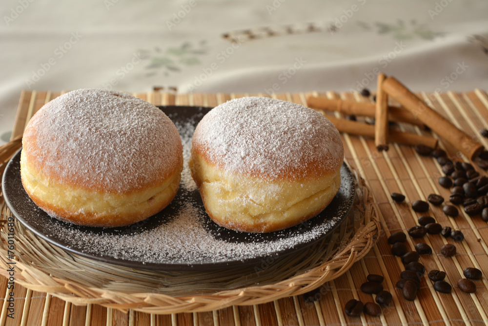 Donuts with powdered sugar on the brown plate