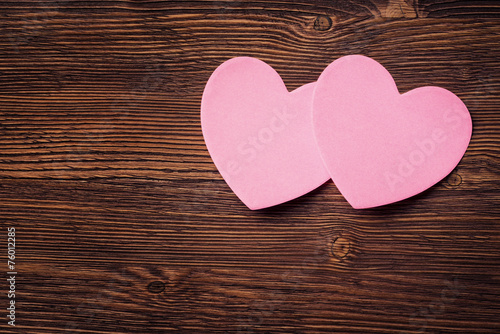 Sticky notes in the form of hearts on vintage wooden background