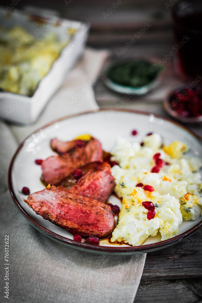 Naklejka premium Grilled steak with cauliflower and pomegranate