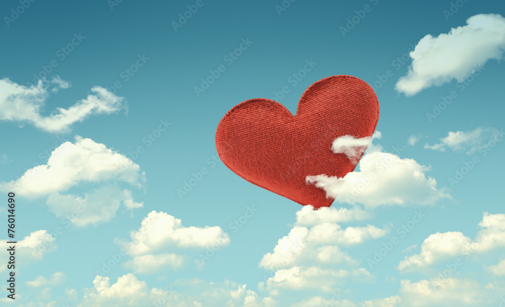 Fabric red heart on blue sky background