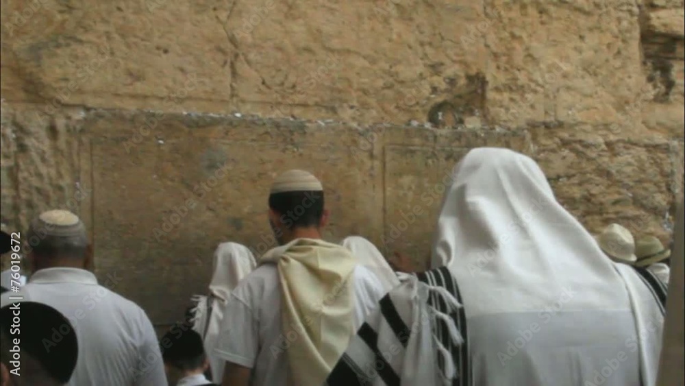 religious Jews in traditional white praying near Western Wall religious Jews in traditional white praying near Western Wall