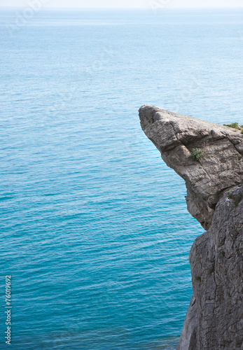High mountain cliff at the calm sea background