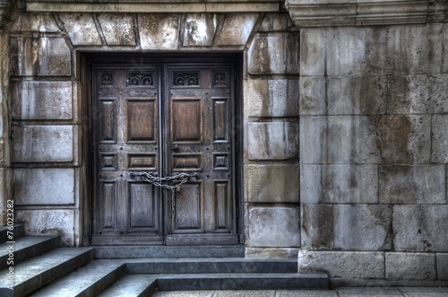 Closed old wooden door into stone wall and stairs