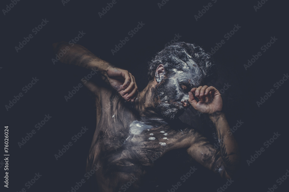 naked man covered with paint and mud skin