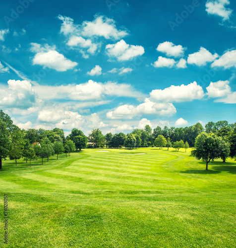 Fotografija Golf field and blue cloudy sky. Beautiful landscape with green g