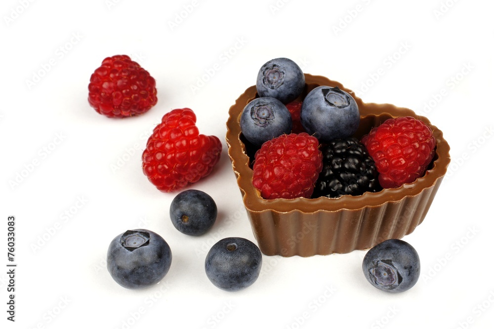 Heart shaped chocolate cup filled with fresh berries over white Heart shaped chocolate cup filled with fresh berries over white