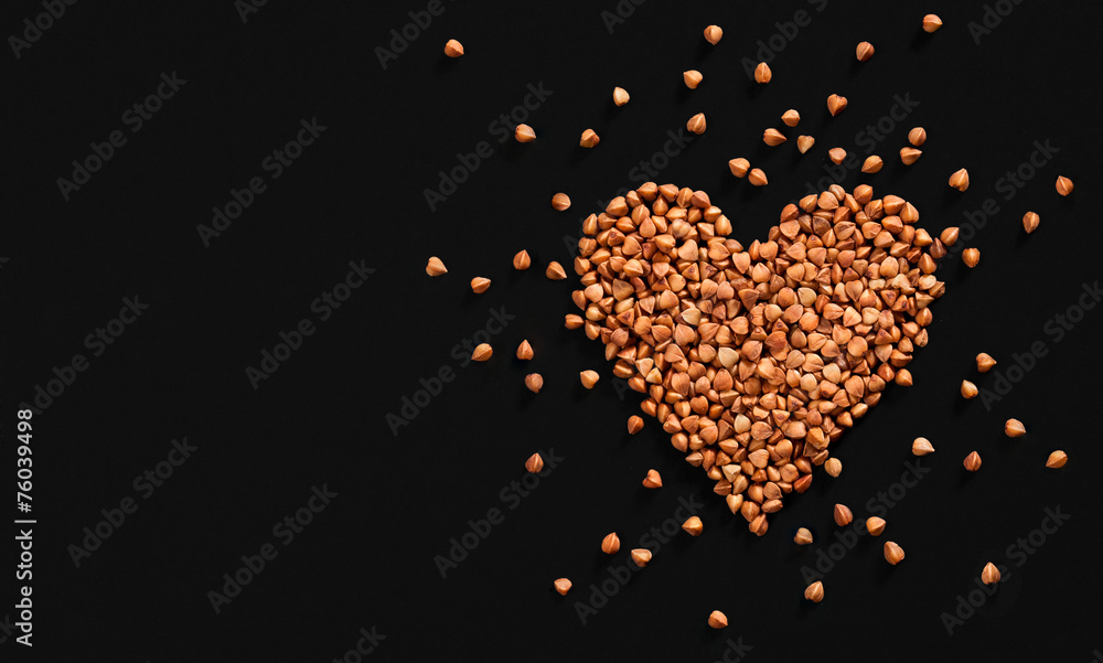Heart-shaped arrangement of premium buckwheat groats on black Heart-shaped arrangement of premium buckwheat groats on black