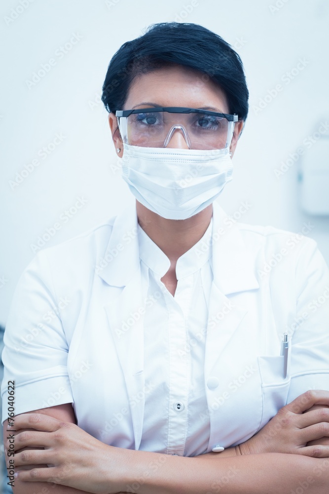 Dentist wearing surgical mask and safety glasses Dentist wearing surgical mask and safety glasses