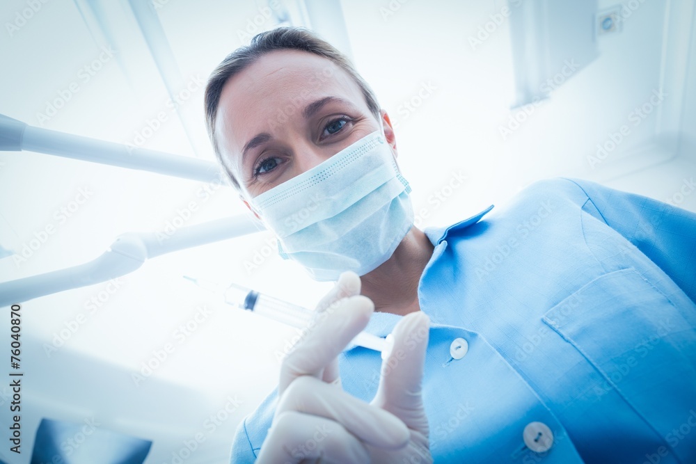 Female dentist in surgical mask holding injection Female dentist in surgical mask holding injection