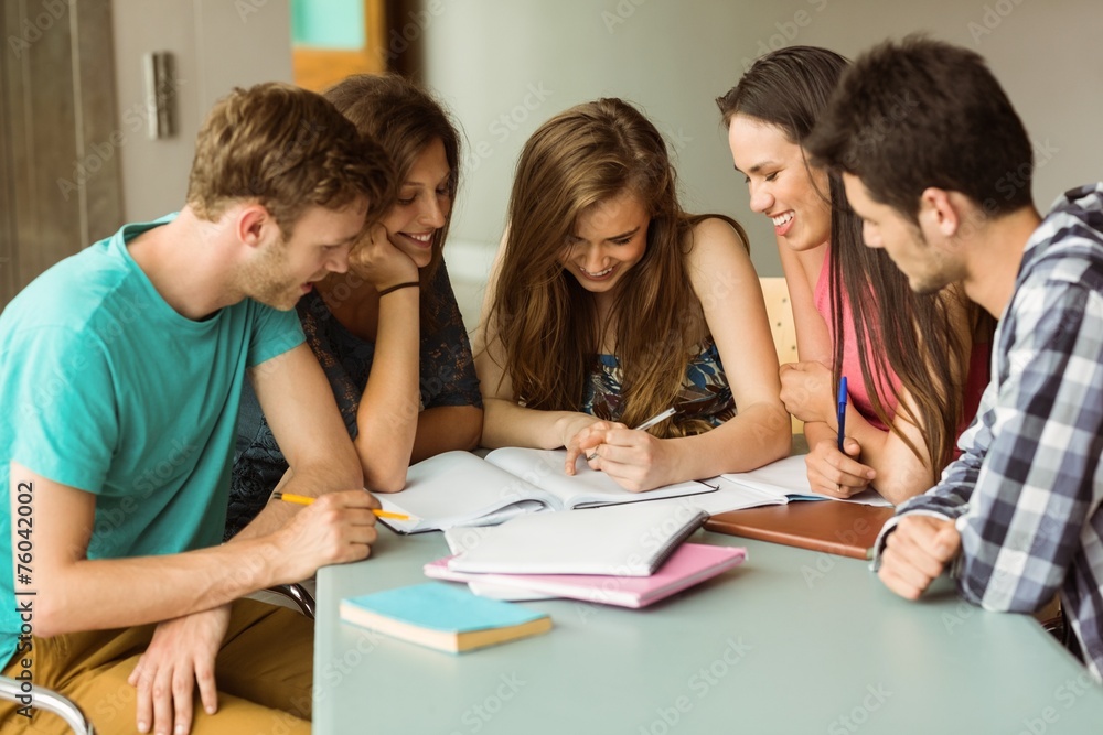 Smiling friends sitting studying together Smiling friends sitting studying together