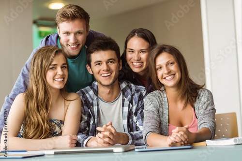 Portrait of smiling friends posing near their laptop