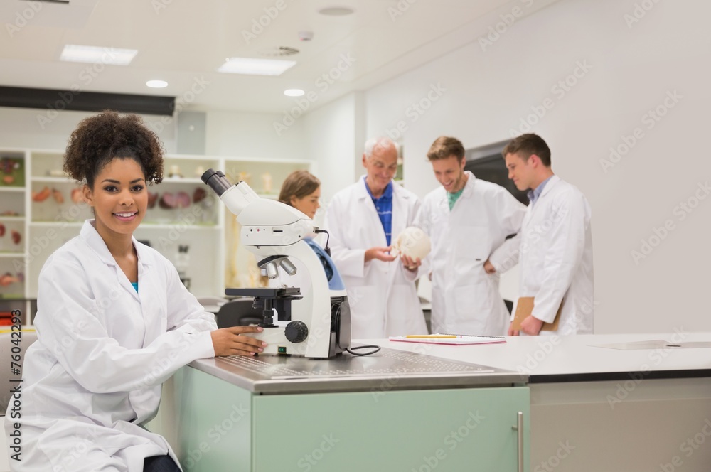 Happy medical student working with microscope Happy medical student working with microscope